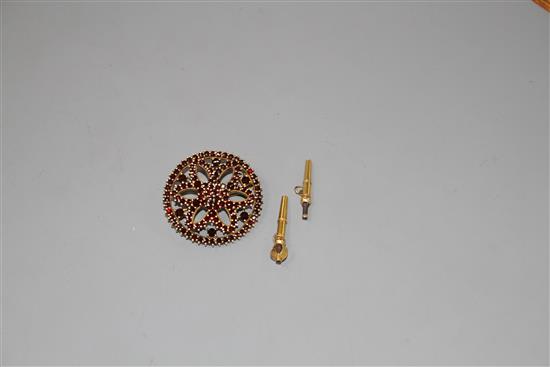 A Victorian pierced yellow metal and garnet set cluster brooch and two watch keys.